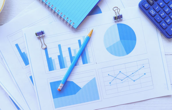 Pencil and calculator on office budgeting paperwork with charts